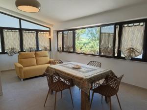 a living room with a table and chairs and a couch at Appartamento - Plemmirio - Villa Maria Serena in Syracuse