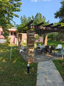 a pergola with a table and chairs in a yard at Beach house IvMare in Ierissos