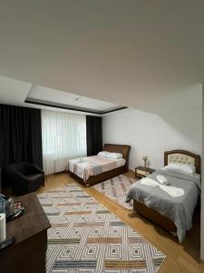 a bedroom with two beds and a rug at Nora Palace Hotel in Develi