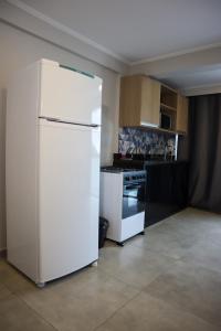a kitchen with a white refrigerator and a stove at Catamarã Pé na Areia in Angra dos Reis