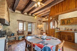 a kitchen with a table and chairs in a room at Le Séchoir D'Alice in Saint-Germain-du-Salembre