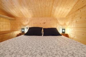 a bedroom with a bed in a wooden cabin at Chalet En Périgord Vert in Sainte-Croix-de-Mareuil +29 photos