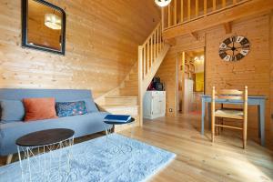 a living room with a blue couch and a table at Chalet En Périgord Vert in Sainte-Croix-de-Mareuil