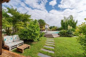 a yard with a couch and a bench and a pool at Chalet En Périgord Vert in Sainte-Croix-de-Mareuil