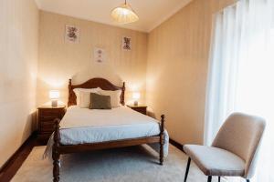 a bedroom with a bed and a chair at Vistas da Villa in Cabeceiras de Basto