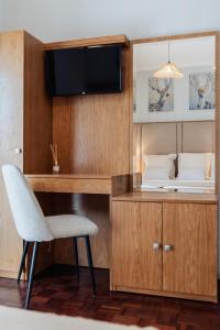 a room with a chair and a desk and a television at Vistas da Villa in Cabeceiras de Basto