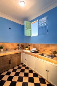 a kitchen with a sink and a checkered floor at Palm Hostel in Marrakesh +8 photos