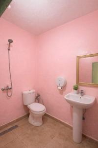 a pink bathroom with a toilet and a sink at Palm Hostel in Marrakesh