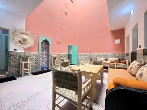 a room with a red wall and a table and chairs at Palm Hostel in Marrakesh