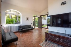 a living room with a couch and a tv at Breathtaking Sea Views & Jacuzzi in Cefalù in Cefalù