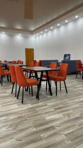 a conference room with tables and orange chairs at Ак-Кеме отель in Bosteri