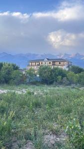 a large building in the middle of a field at Ак-Кеме отель in Bosteri