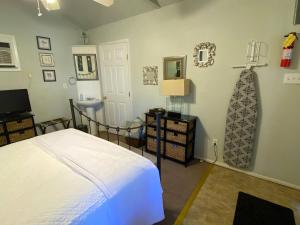 a bedroom with a white bed and a sink at Four Winds Victorian Venue & Suites in Bonham