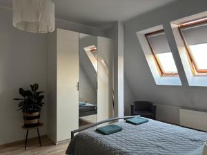 a bedroom with a bed and two skylights at Apartament Królewiecka in Płock