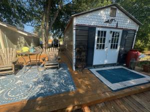 a small shed with a table and chairs on a deck at Four Winds Victorian Venue & Suites in Bonham