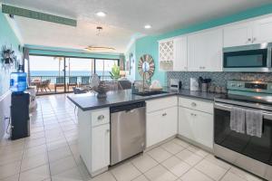 a kitchen with white cabinets and a view of the ocean at Sonoran Spa Amazing Oceanfront E206 in Puerto Peñasco