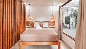 a bedroom with a bed and a window at White Palm Villa 1 in General Luna