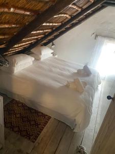 a large white bed with two teddy bears on it at The Coach House Bredasdorp in Bredasdorp