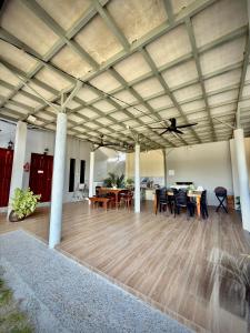 a large room with a wooden floor and tables and chairs at Ummi Studio Homestay in Bayan Lepas