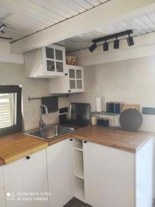 a small kitchen with white cabinets and a sink at House Silvana in Postira