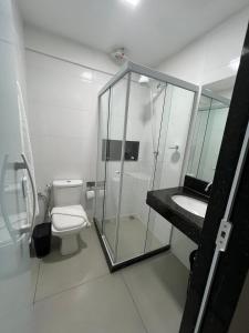 a bathroom with a shower and a toilet and a sink at Catamarã Pé na Areia in Angra dos Reis