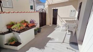 a patio with a table and chairs and potted plants at Apartment Murva in Primošten