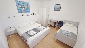 a small bedroom with two beds and a desk at Apartment Murva in Primošten