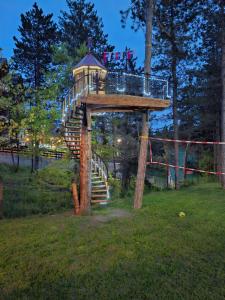 a tree house with a staircase in a park at Apartmani Sredojevic in Kaludjerske Bare