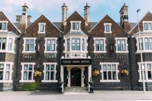 a large brick building with the entrance to the main arms hotel at Adair Arms Hotel in Ballymena