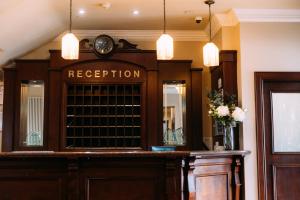 a reception desk with a clock on top of it at Adair Arms Hotel in Ballymena