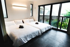 a bedroom with a large bed with two towels on it at SANMI Hayama in Hayama