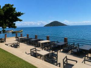 a group of tables and chairs next to the water at Summerland Lodge in Chembe +3 photos