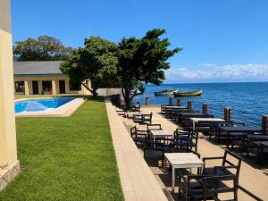 a row of tables and chairs next to the water at Summerland Lodge in Chembe