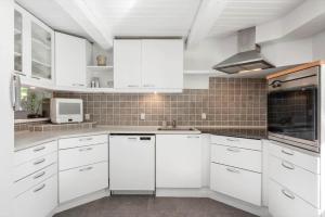 a white kitchen with white cabinets and a microwave at SJ342-Vamdrup-Holtvej-11-sommerhus in Vamdrup +24 photos