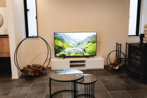 a living room with a tv and two chairs and a table at SANMI Hayama in Hayama