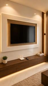 a living room with a large television on a wall at The Luxe Cottage in Ikeja