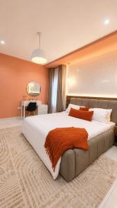 a bedroom with a large bed and a desk at The Luxe Cottage in Ikeja