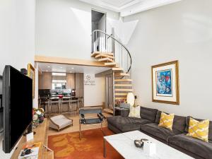 a living room with a couch and a staircase at Lionshead Center in Vail