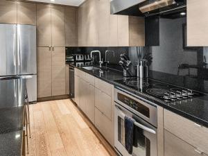 a kitchen with stainless steel appliances and black counter tops at Lionshead Center in Vail +18 photos