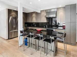 a kitchen with a large black island with bar stools at Lionshead Center in Vail