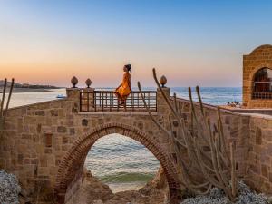a woman standing on a bridge over the ocean at Movenpick Resort El Quseir in Quseir