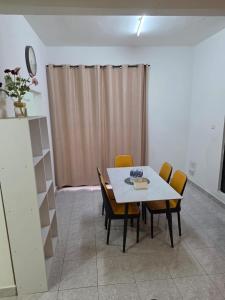 a dining room with a white table and chairs at Osvy Palm Homestay in Penampang