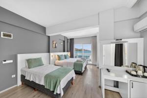 a hotel room with two beds and a desk at Mia Casa Hotel in Fethiye +42 photos