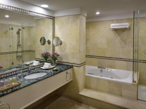 a bathroom with a tub and a sink at Mövenpick Resort & Spa Dead Sea in Sowayma +246 photos