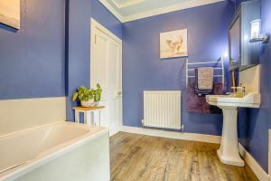a blue bathroom with a tub and a sink at 3 Bed in Lintrathen oc-w42585 in Bridgend of Lintrathen +32 photos