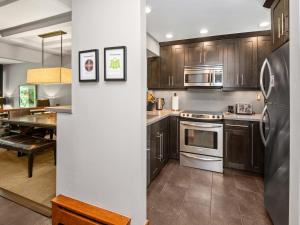 a kitchen with wooden cabinets and stainless steel appliances at Ptarmigan Townhome 2 in Vail