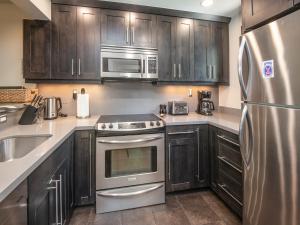 a kitchen with stainless steel appliances and wooden cabinets at Ptarmigan Townhome 2 in Vail
