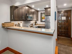 a kitchen with wooden cabinets and a counter top at Ptarmigan Townhome 2 in Vail +19 photos
