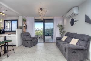 a living room with a couch and two chairs and a kitchen at דיאמנט - Diamond in Safed