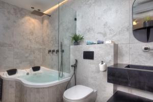 a bathroom with a tub and a toilet and a shower at דיאמנט - Diamond in Safed